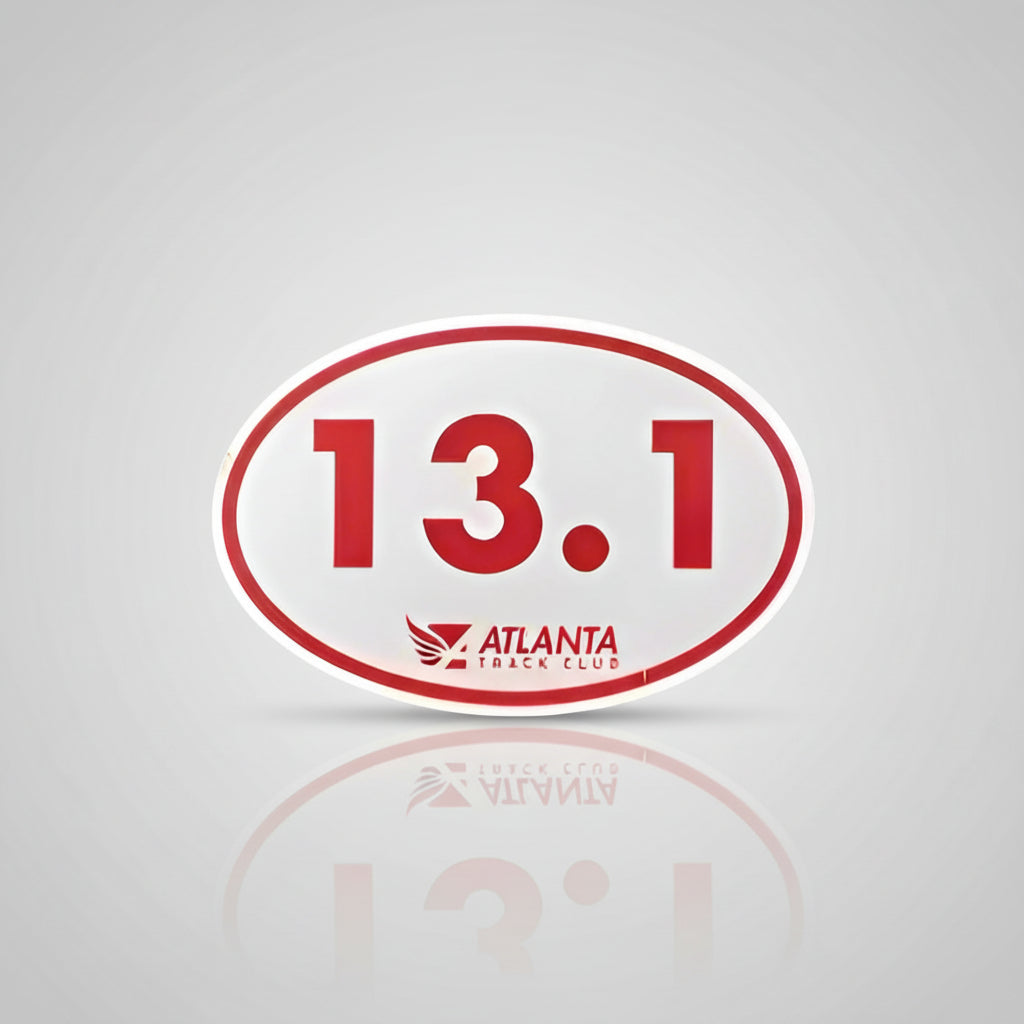 A white oval magnet with the number 13.1 in red, and the Atlanta Track Club logo in red and white.