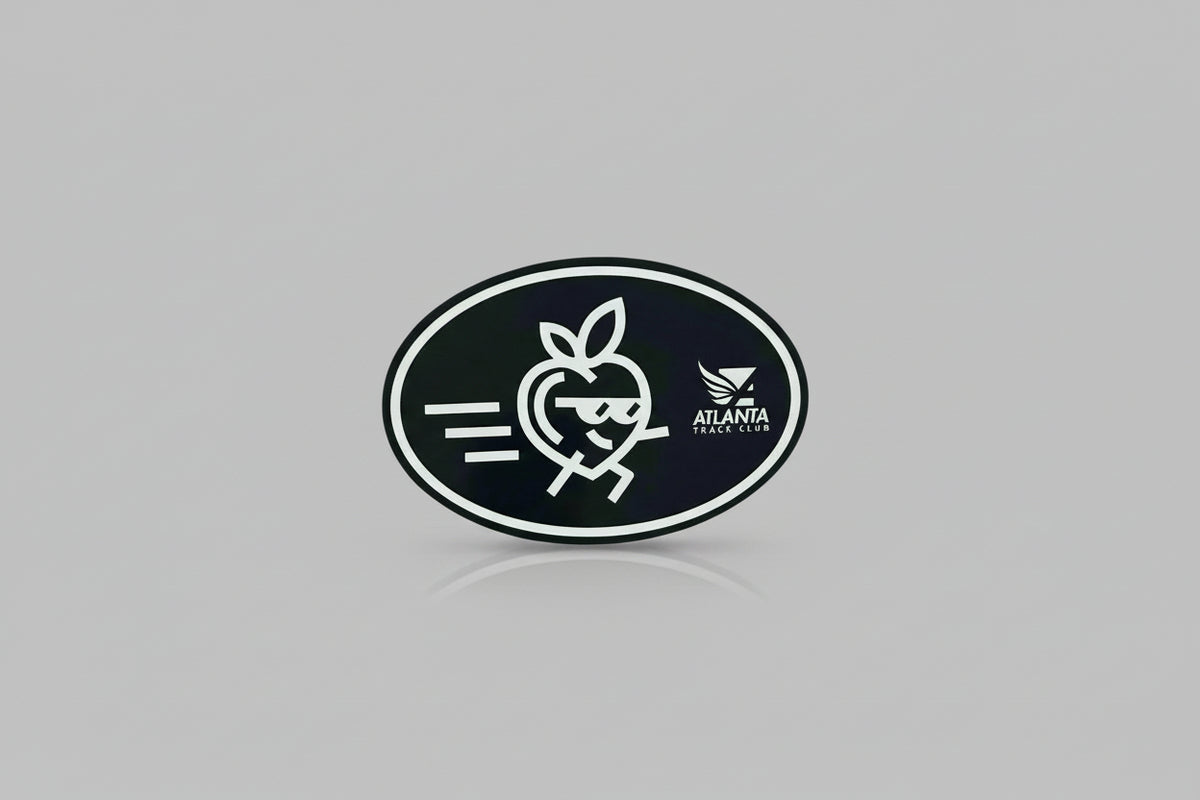 A black oval-shaped magnet with a white graphic design of Pete the Peach with a face and sunglasses, alongside text that reads 'ATLANTA TRACK CLUB'.