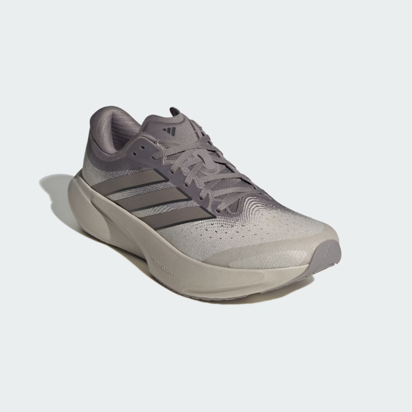 A single Adidas running shoe in a light gray and taupe colorway, shown from a three-quarters angle against a light gray background.